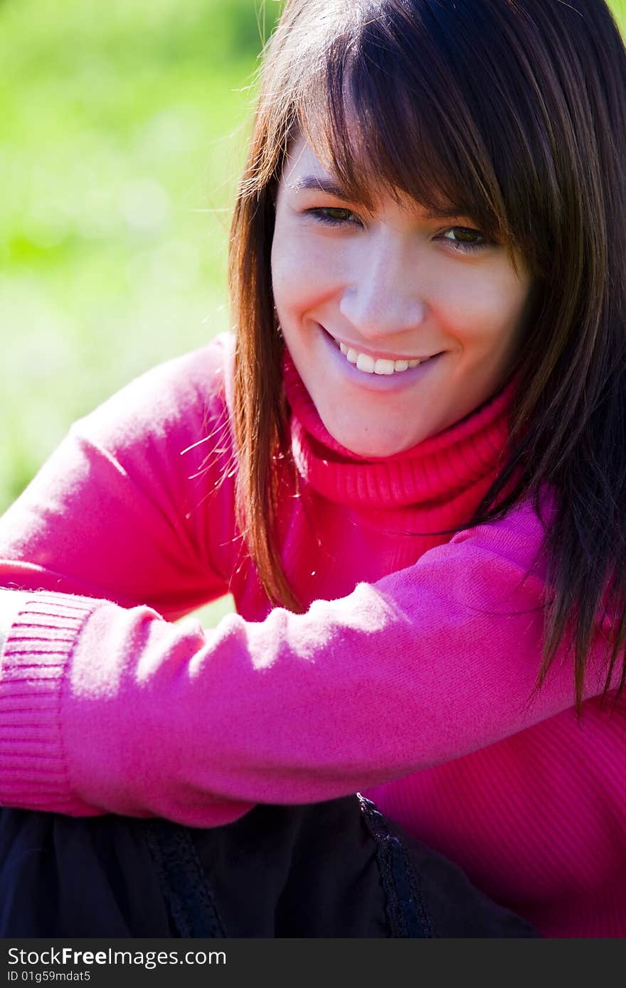 Young smiling woman over green background.