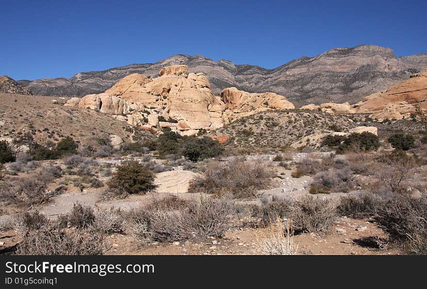 Brown and red desert landscape under a vivid blue sky