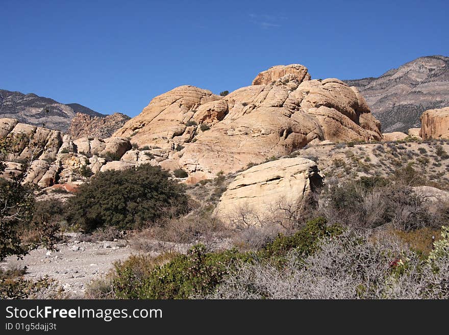 Brown and red desert landscape under a vivid blue sky