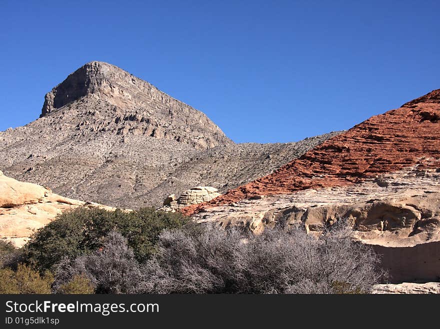 Brown and red desert landscape under a vivid blue sky