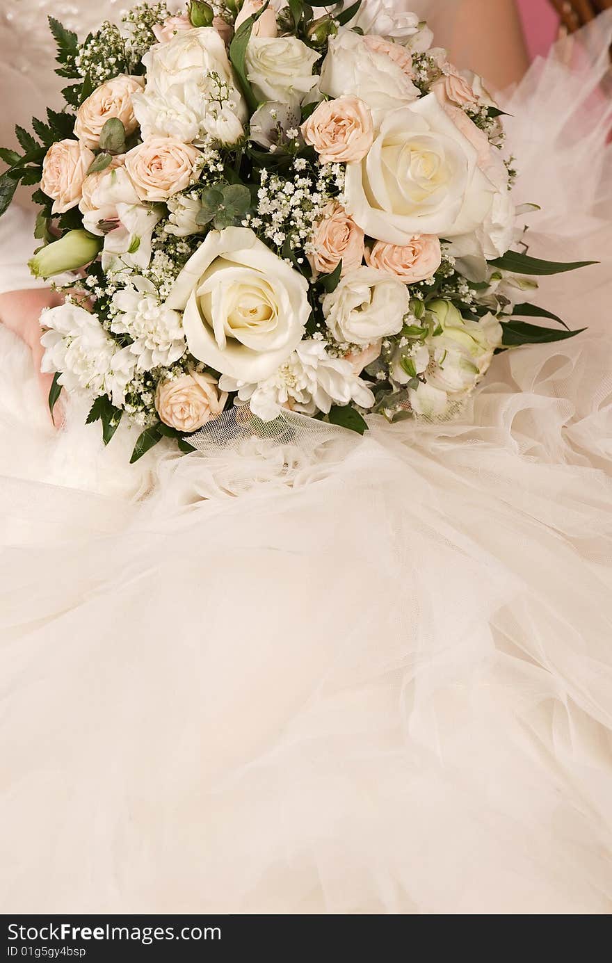 Wedding bouquet on a background of dress of the bride