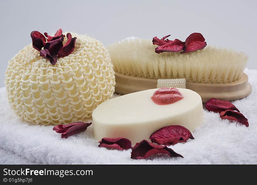 Bath product arrangement on white towel decorated with red dry flowers. Bath product arrangement on white towel decorated with red dry flowers