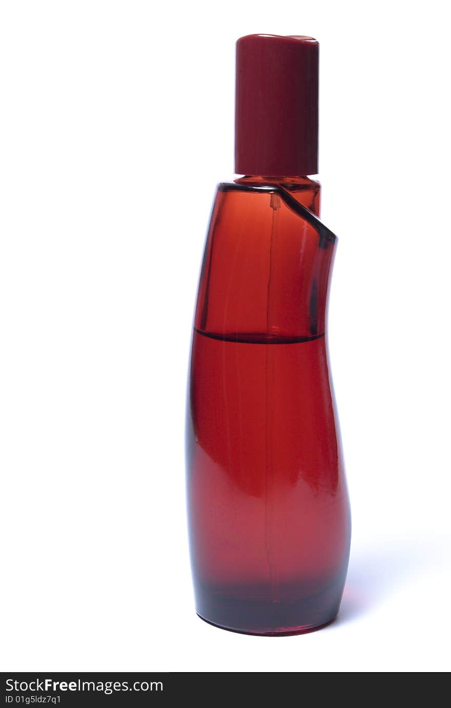 A blank glass fragrance bottle with a clear liquid inside sitting on a glass surface.