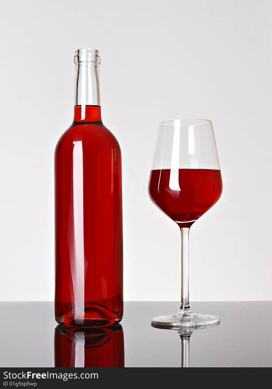 Glass of red wine and bottle over white background. Glass of red wine and bottle over white background