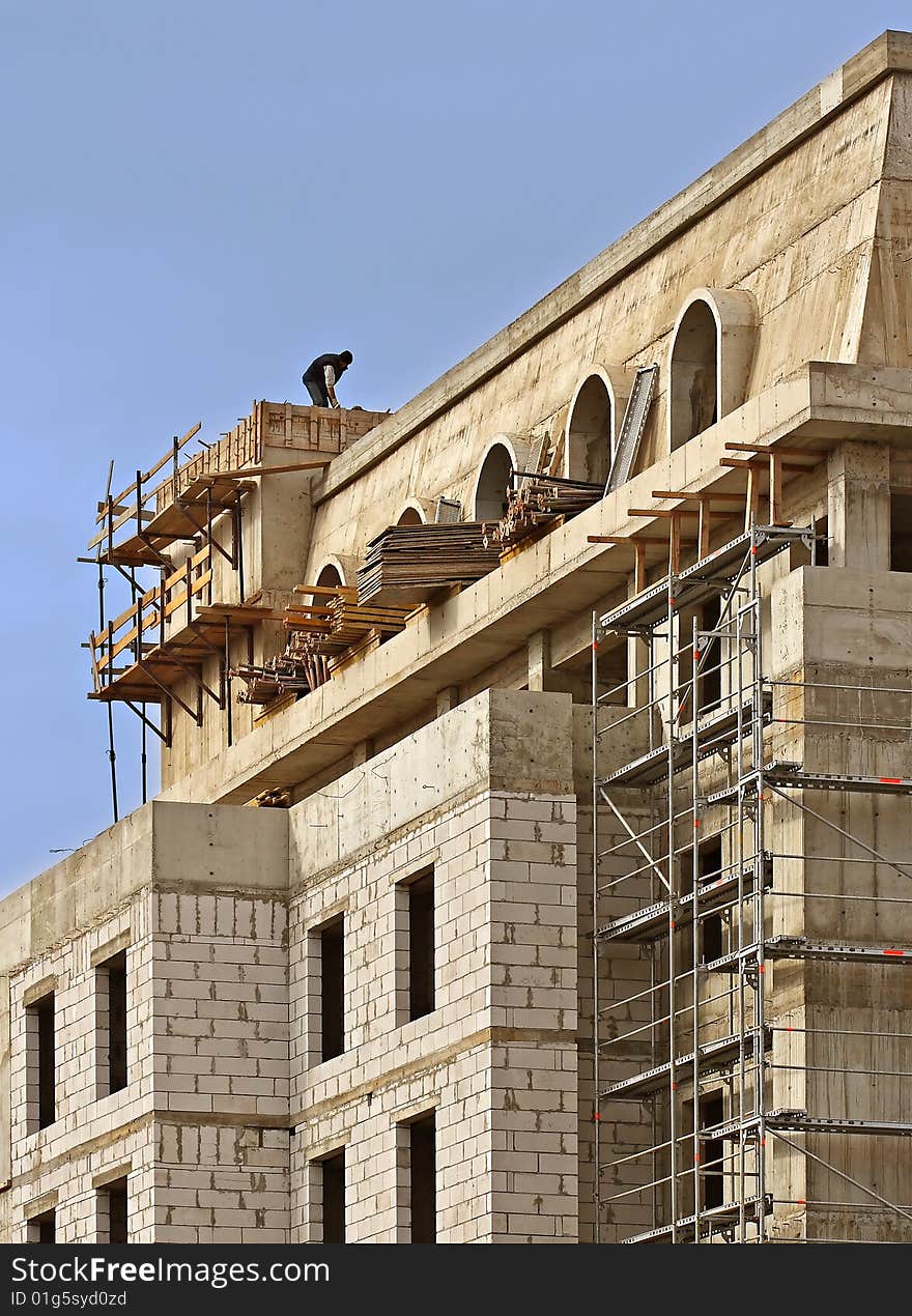 A construction worker on a high wall