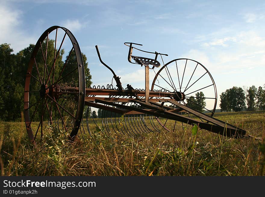 Closeup of a sample of vintage farming equipment on a country field. Closeup of a sample of vintage farming equipment on a country field.