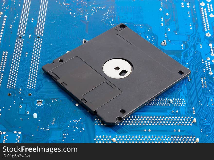 Outdated technology memories: black floppy disk on blue background