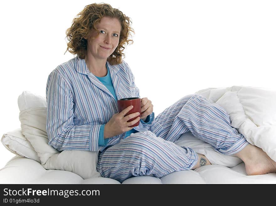 30 something female relaxes in bed with hot drink. 30 something female relaxes in bed with hot drink