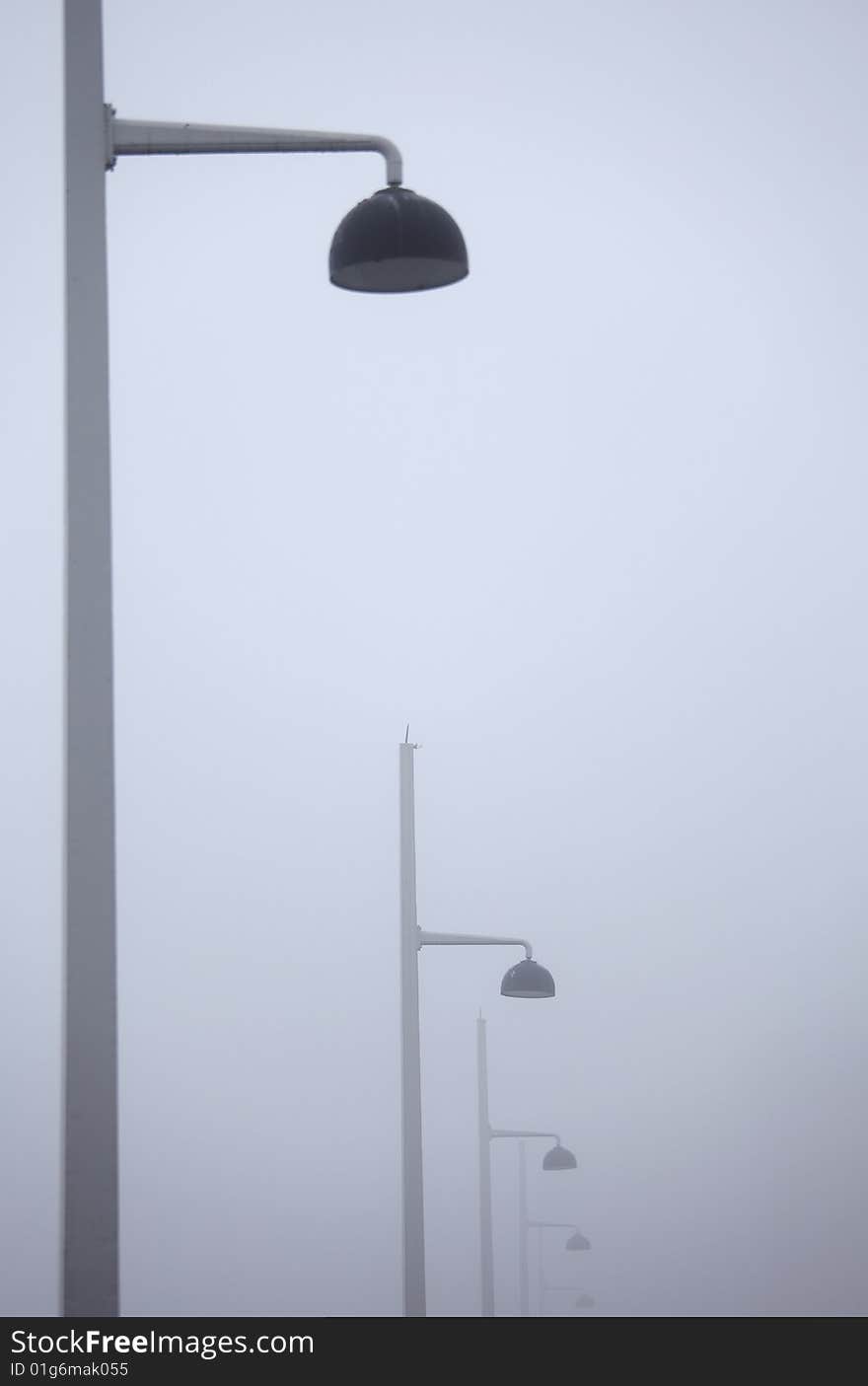 Lined lamps in a misty morning