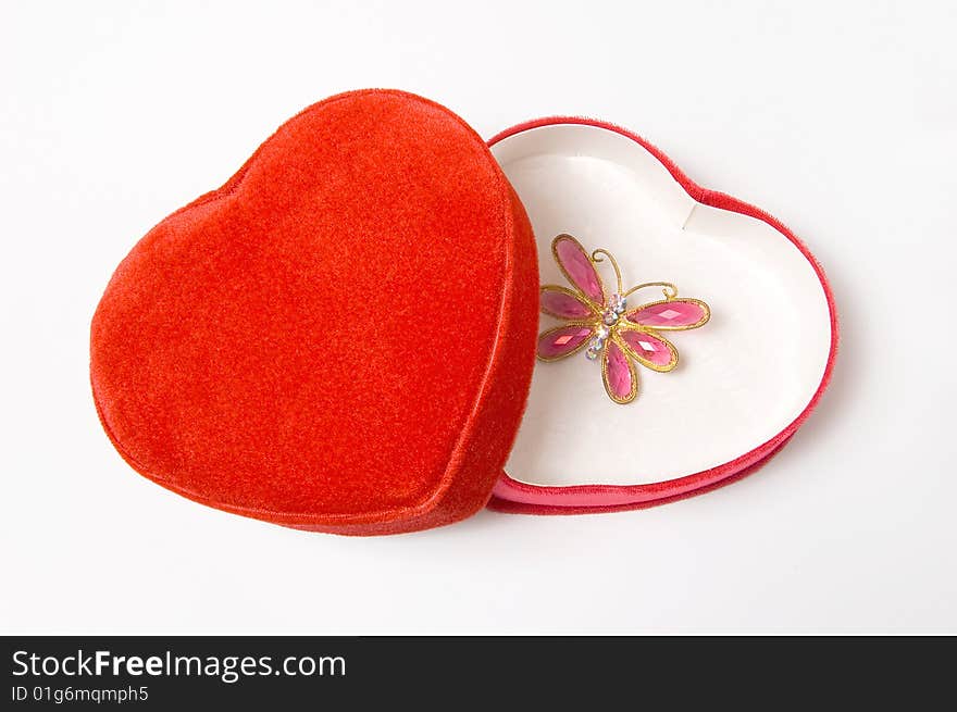 Heart shaped red gift box with butterfly shaped pendant, isolated on white. Heart shaped red gift box with butterfly shaped pendant, isolated on white