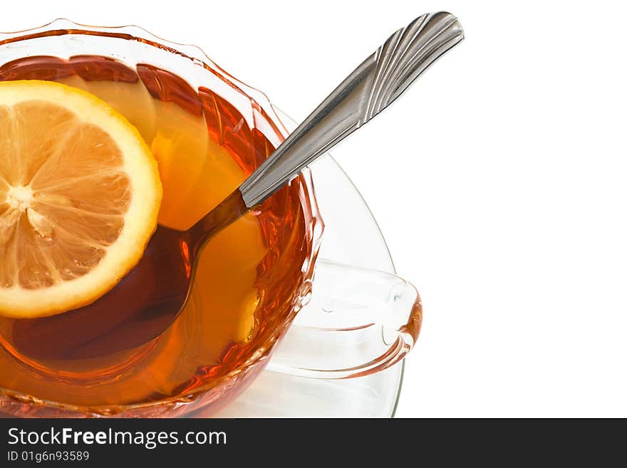 Glass cup with tea and a lemon on a white background