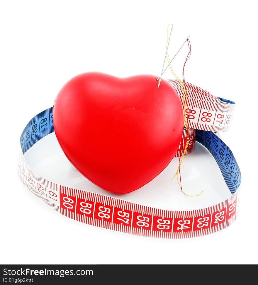 Heart shaped pincushion and measuring tape isolated on a white background