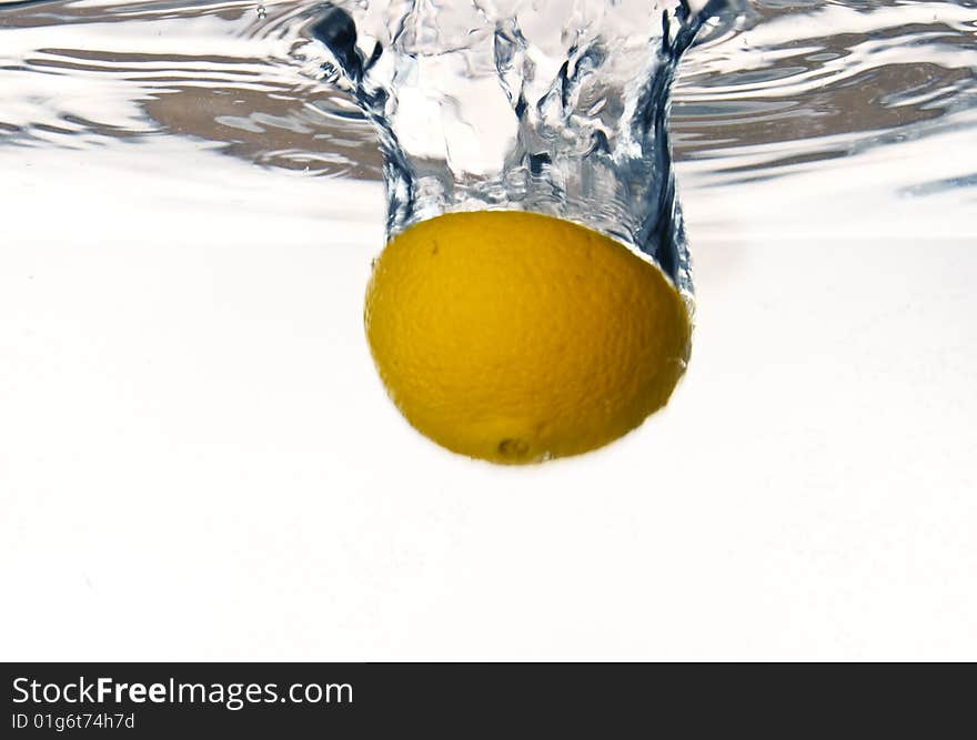 Orange falling into water with water splash