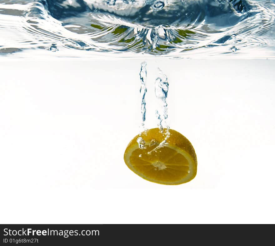 Orange falling into water with water splash