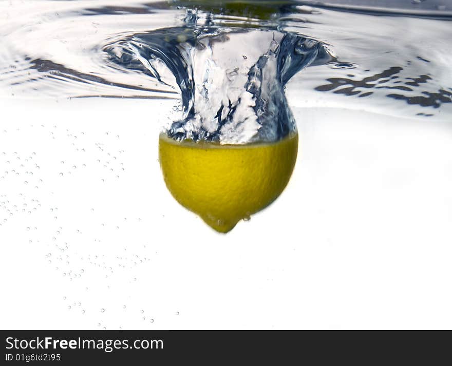 Lemon dropped into water with water splash