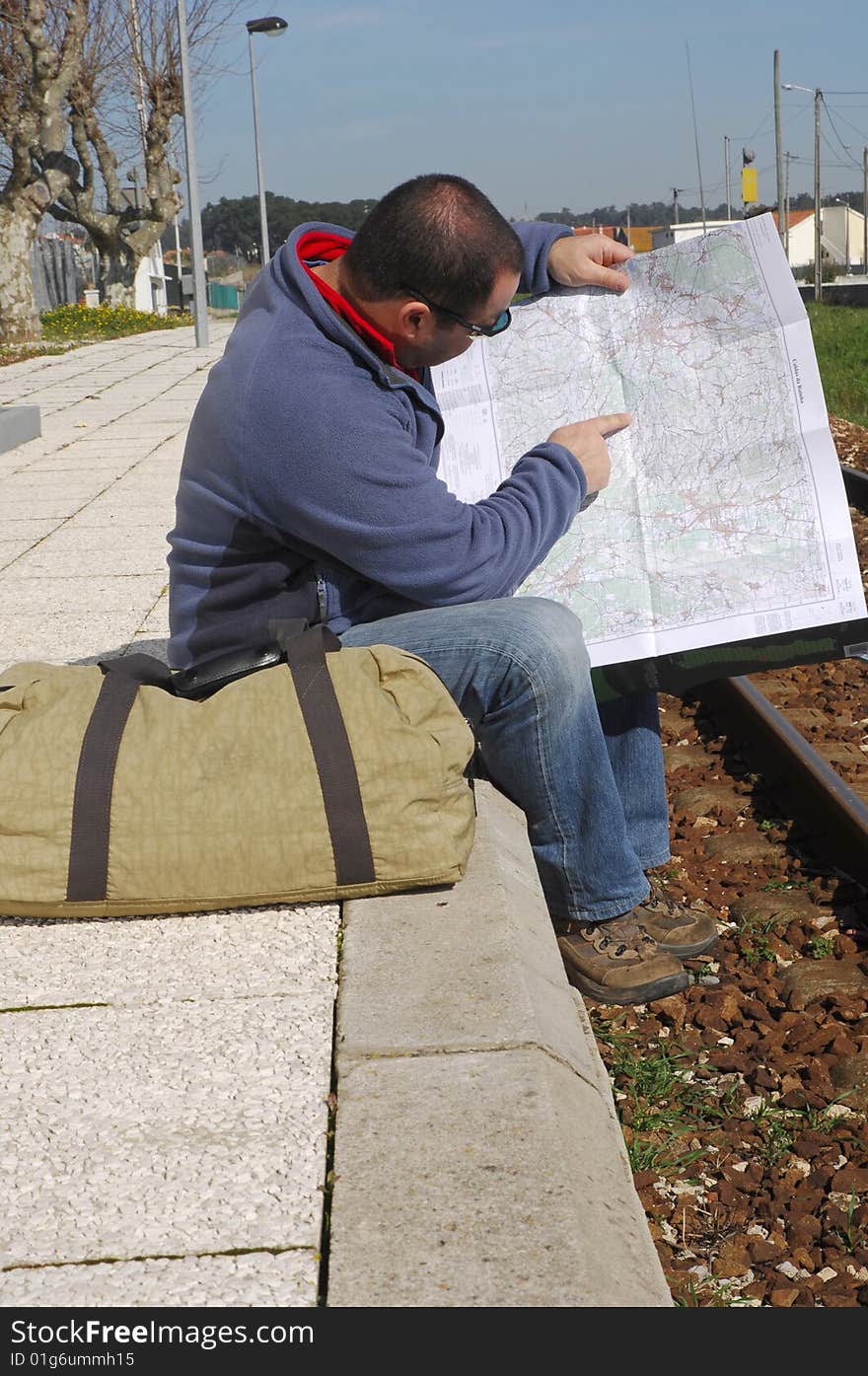 Men waiting for the train and looking a map