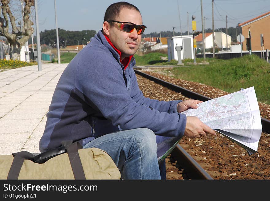 Men waiting for the train and looking a map