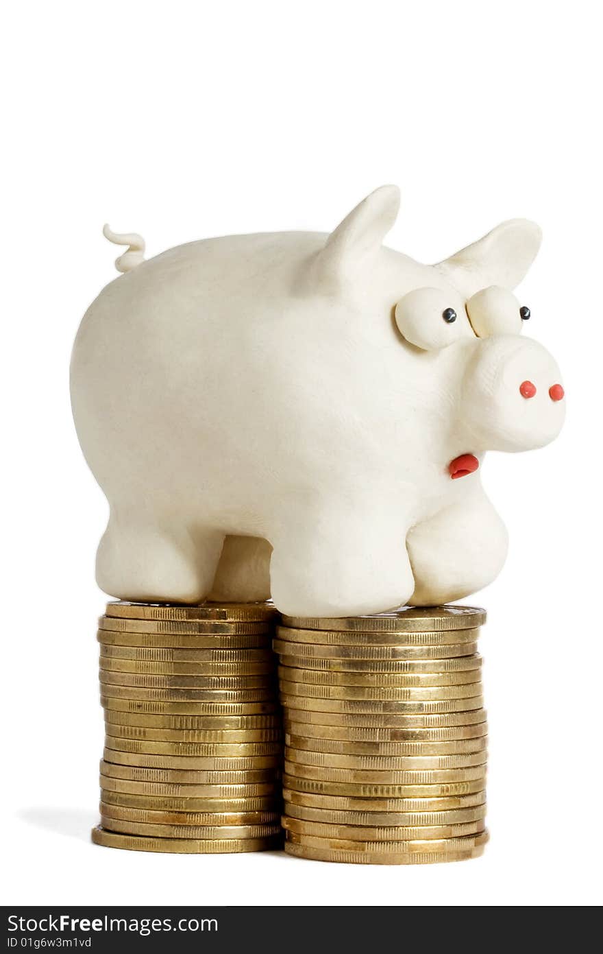 Plasticine piggy bank stands on heaps of gold coins