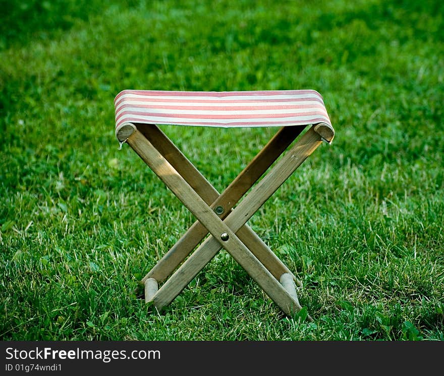 An X shaped seat on the lawn. An X shaped seat on the lawn