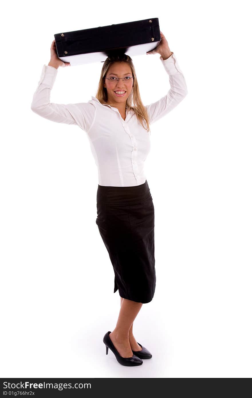 Side view of young businesswoman putting briefcase on her head against white background