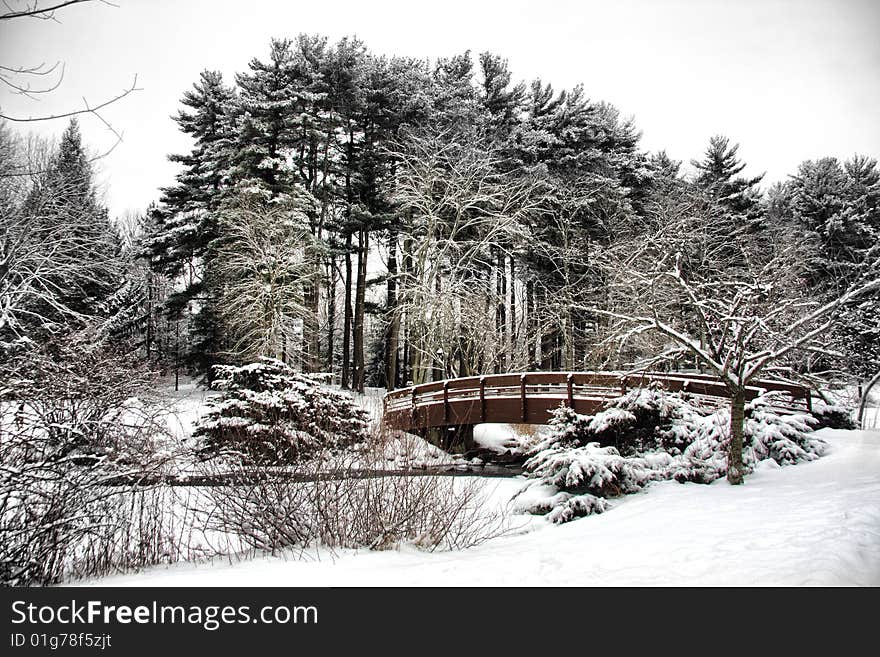 View of snow covered outdoor park with bridge over a stream.  Location is Armonk, NY. View of snow covered outdoor park with bridge over a stream.  Location is Armonk, NY.