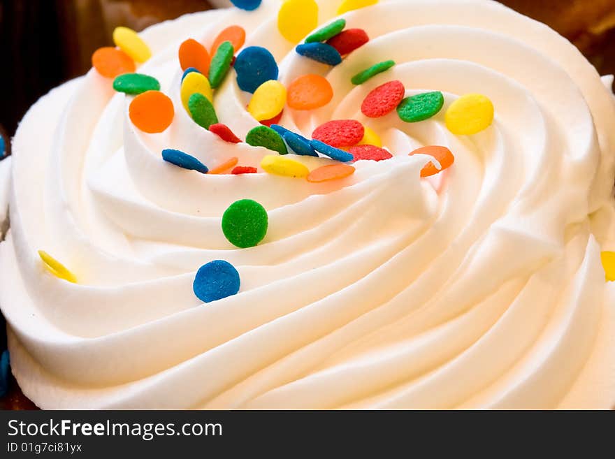 Freshly baked cupcakes close up with colored candies on the frosting