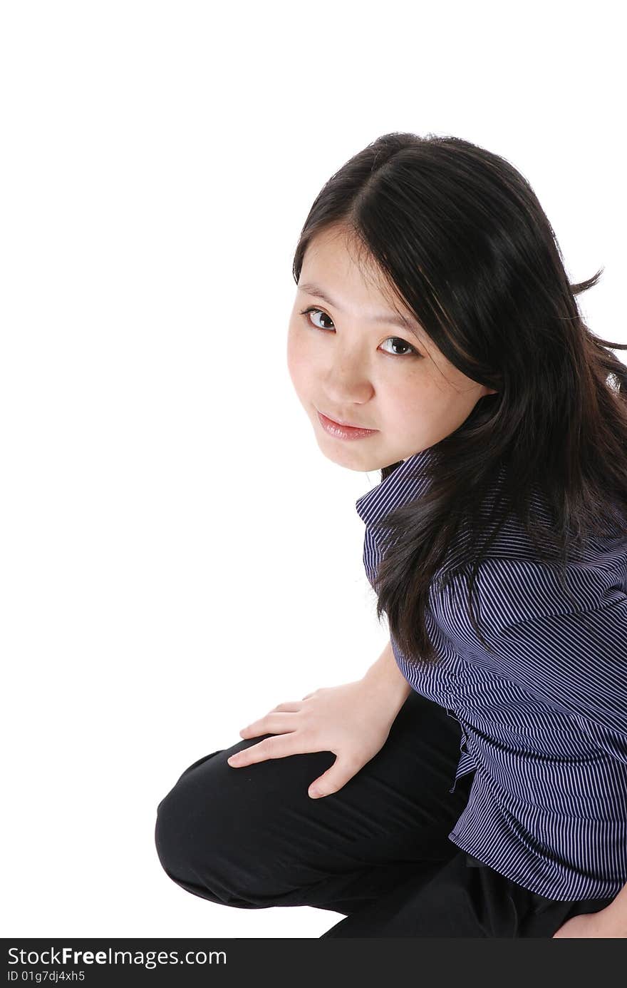 Young chinese girl squatting on the floor isaolted over white