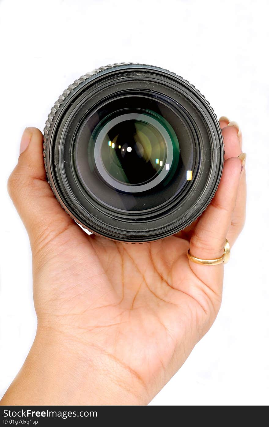 Female hand holding a camera lens.