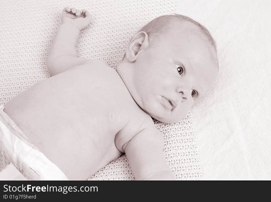 Month old baby boy on a light blanket. Sepia Tone