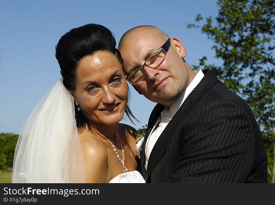 A very happy wedding couple standing close together.