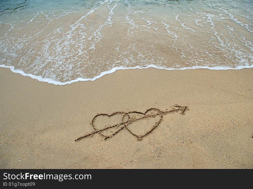 2 Hearts drawn on the surfy beach, concept of love. 2 Hearts drawn on the surfy beach, concept of love