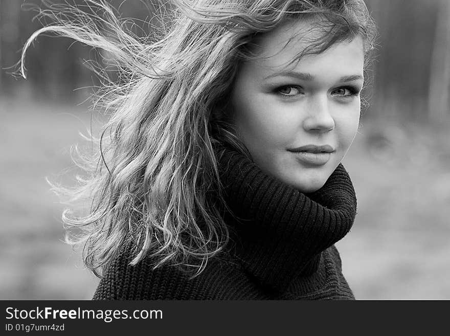 Black and white portrait of woman walking against wind with flowing hair. Black and white portrait of woman walking against wind with flowing hair