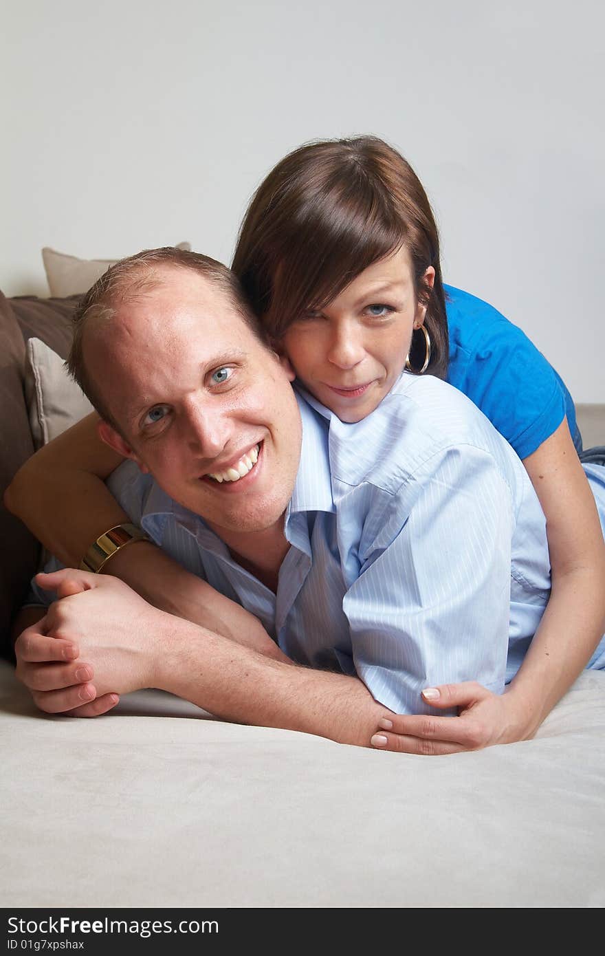 Beautiful young couple on a couch in their new appartment. Beautiful young couple on a couch in their new appartment.