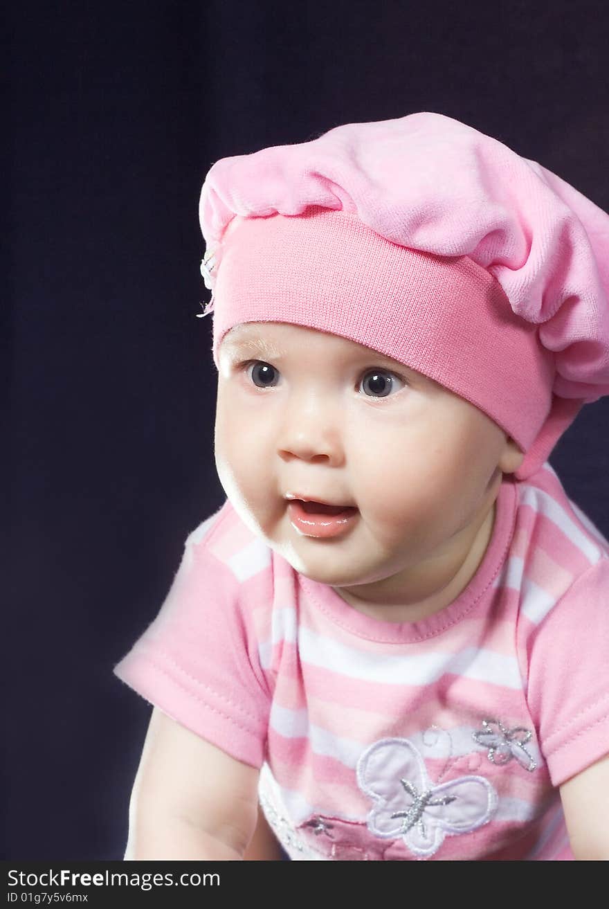 Child sits in red hat and looks with surprise. Child sits in red hat and looks with surprise