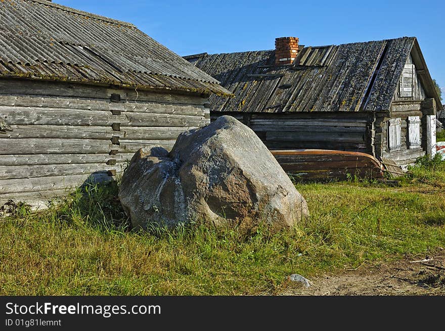 Big boulder near the old wooden shed in russian village. Big boulder near the old wooden shed in russian village