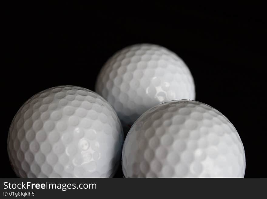 Three Golf balls on black background