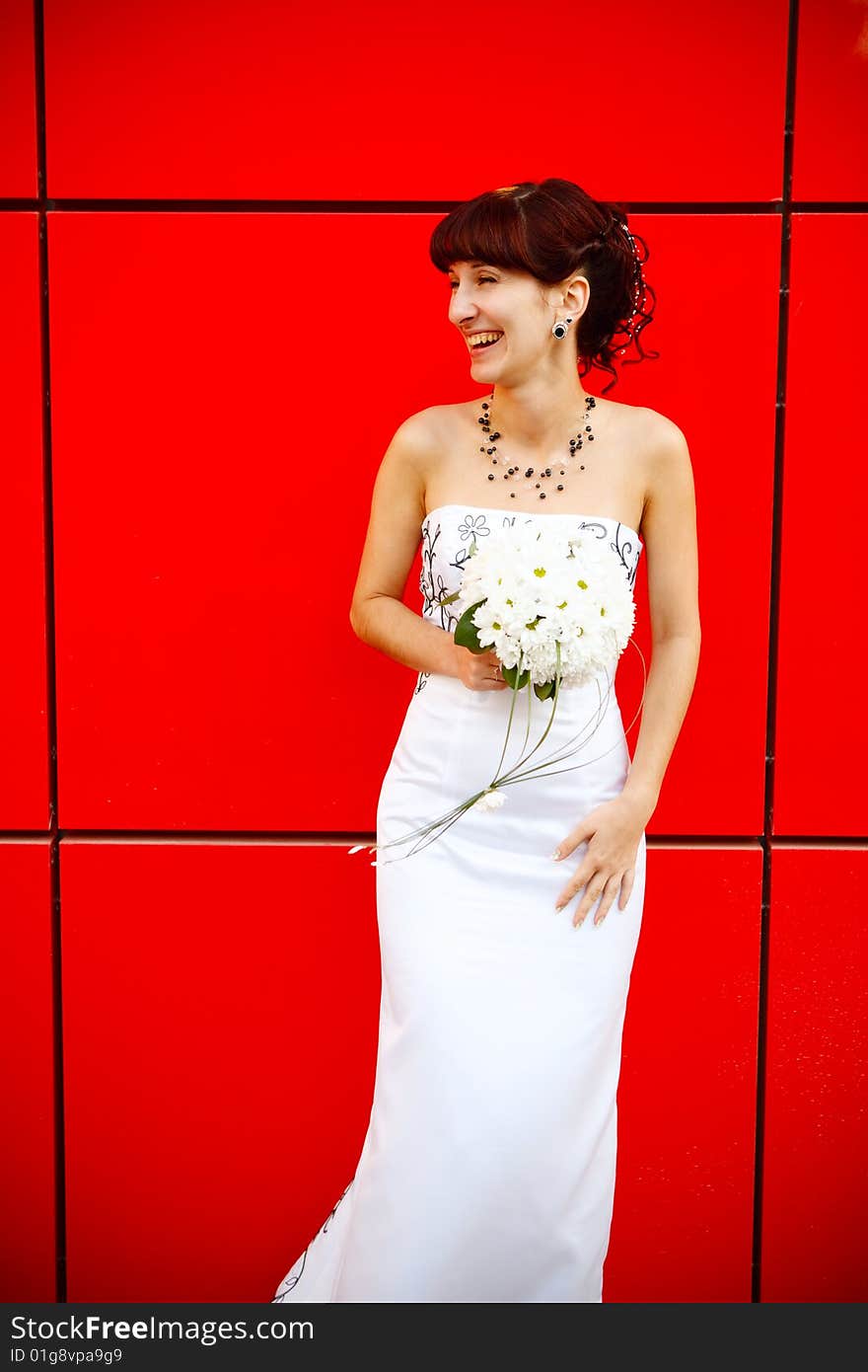 Funny bride by the red wall. Funny bride by the red wall