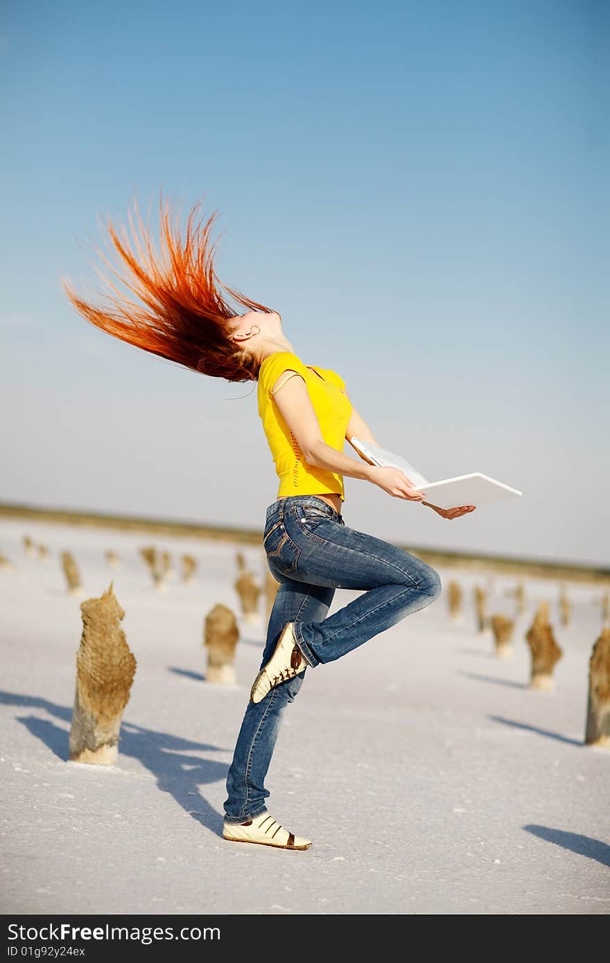 Dancing girl with notebook in the desert