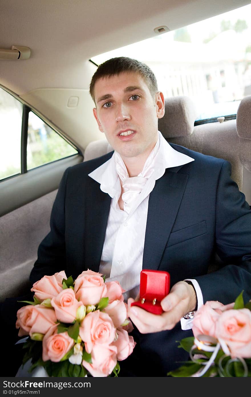 Groom with rings and flowers in the car. Groom with rings and flowers in the car