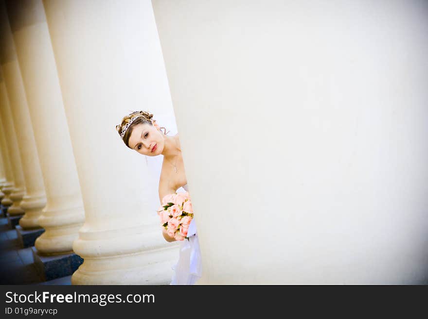 A bride hiding in columns. A bride hiding in columns