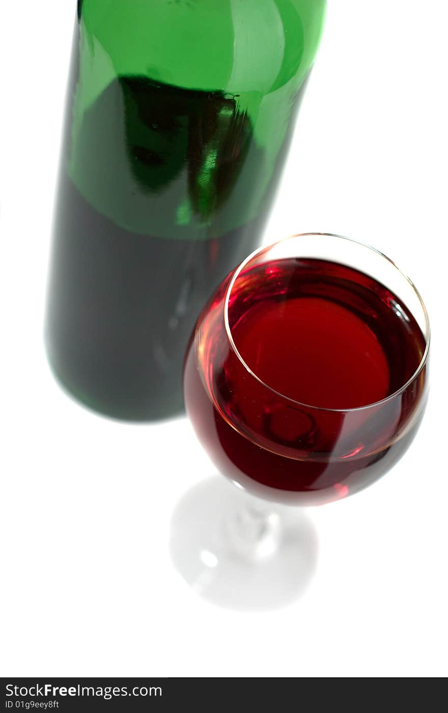 Bottle and glass of red wine on a white background