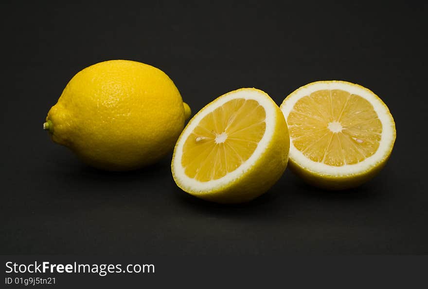 Ripe and cut lemon on a black background