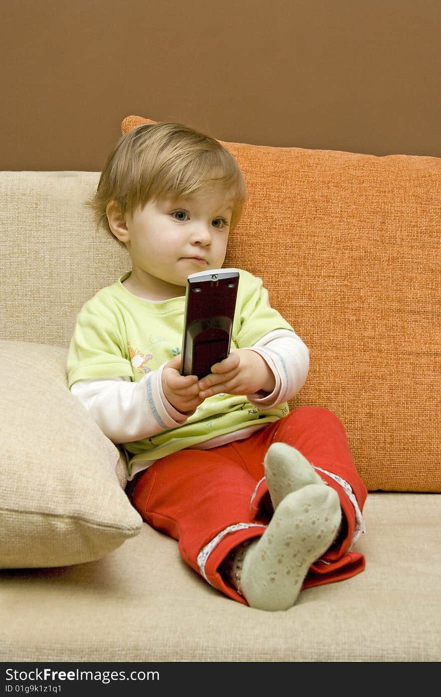 Baby girl with remote control on  sofa