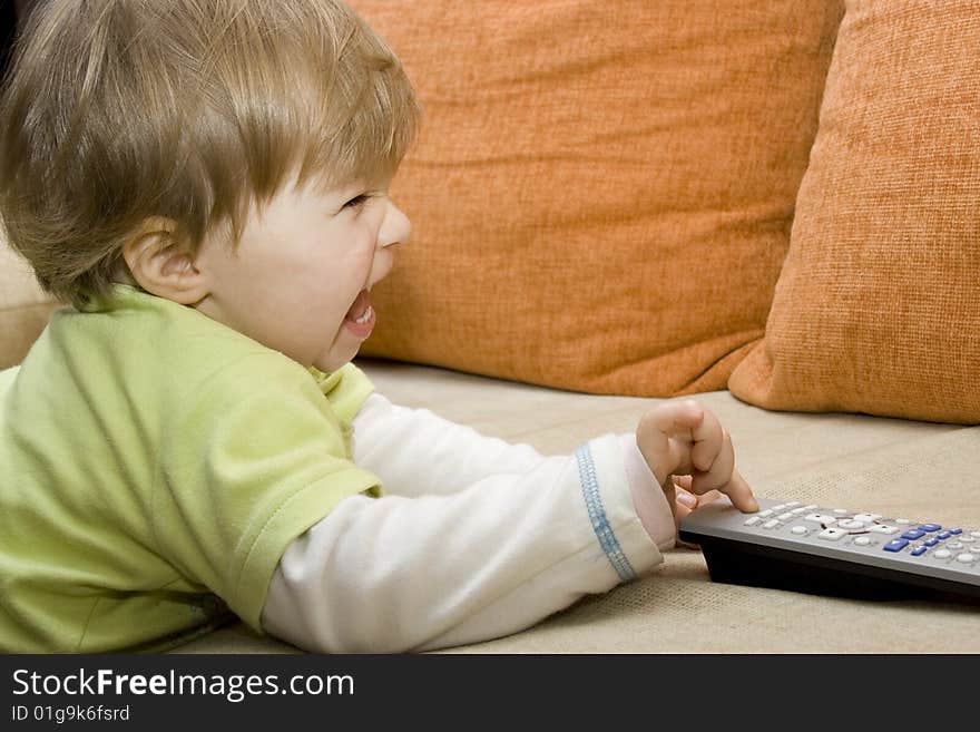 Baby girl with remote control on  sofa