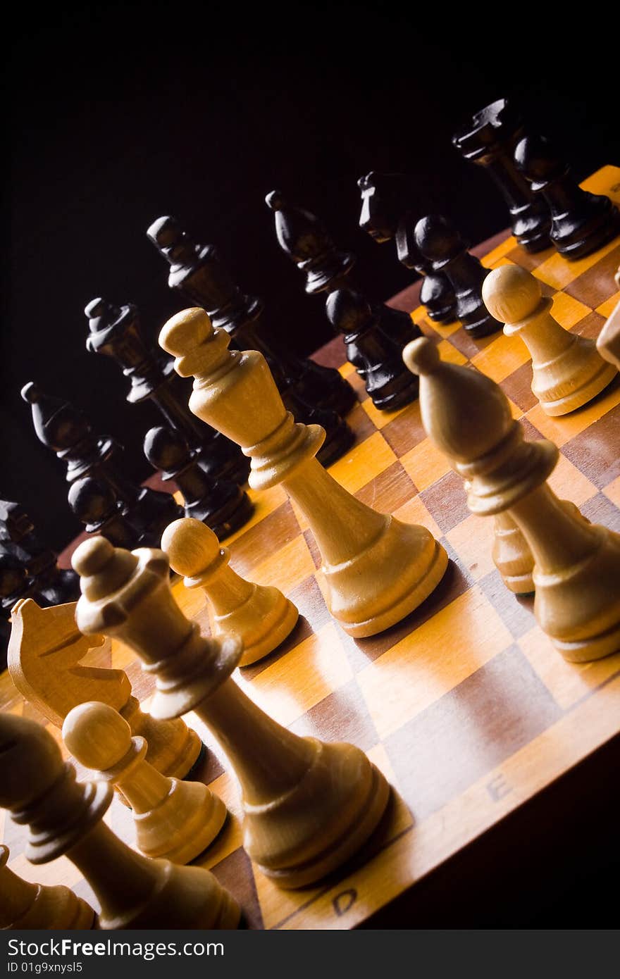 Old Craved wooden Chess pieces on a Board