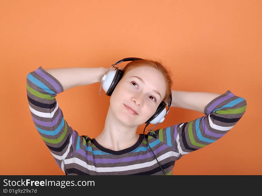 Redhead young woman in headphones with copy space