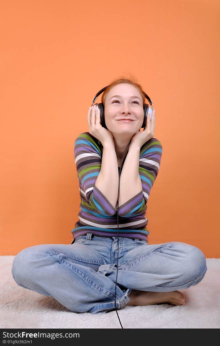 Redhead young woman in headphones with copy space