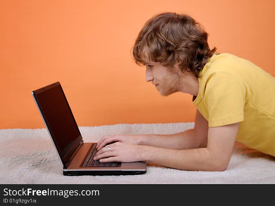 The man with the laptop on an orange background