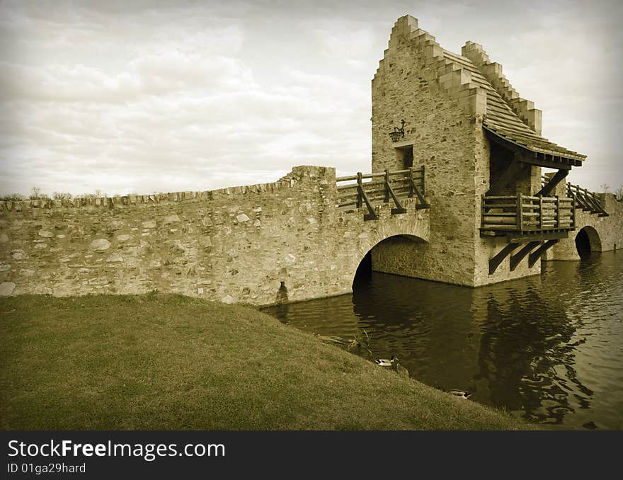 Colorized Ancient Medieval Raplica Bridge Over River Water.