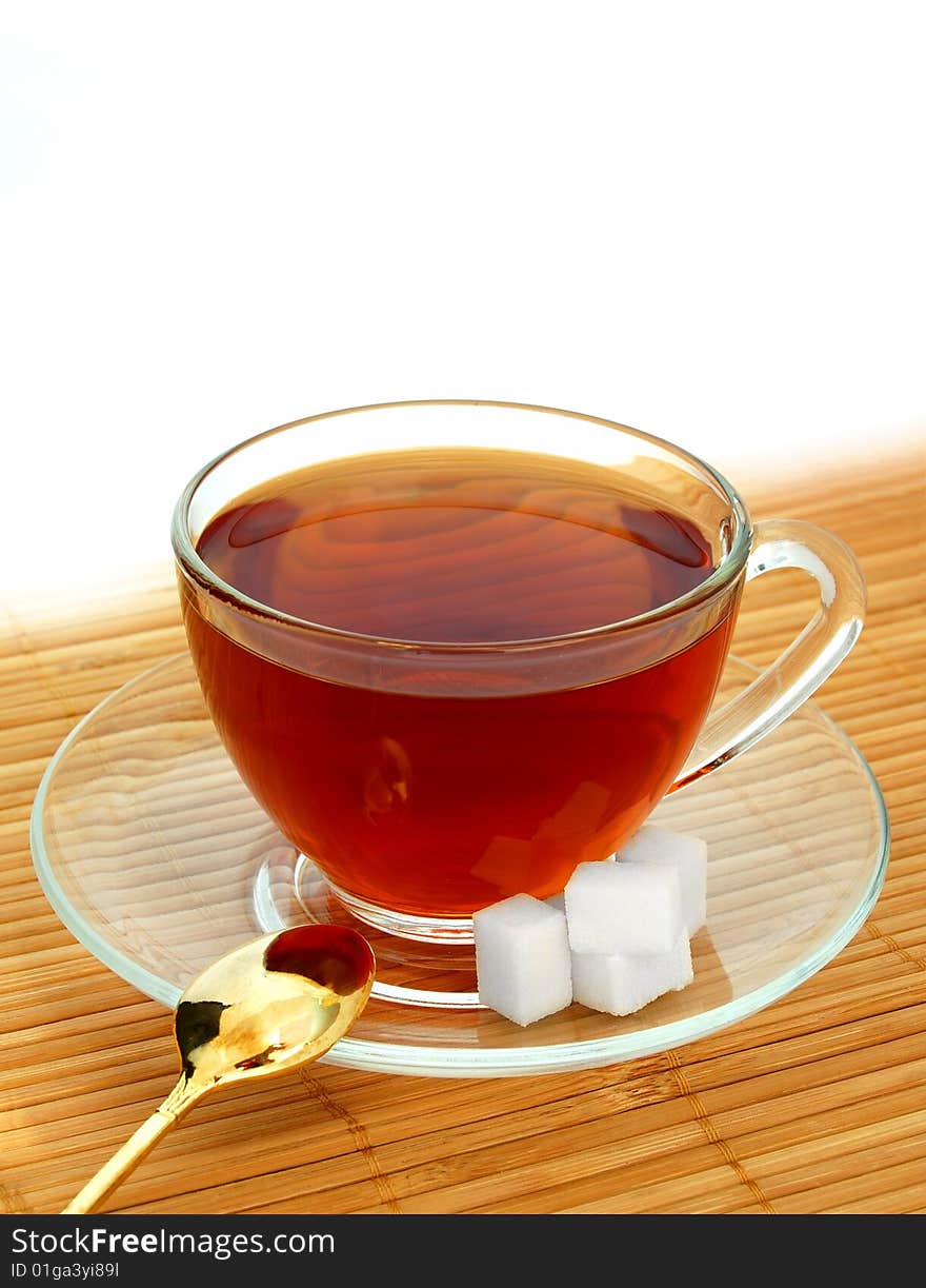 Glass Cup of Tea With Gold Spoon and Sugar Cubes